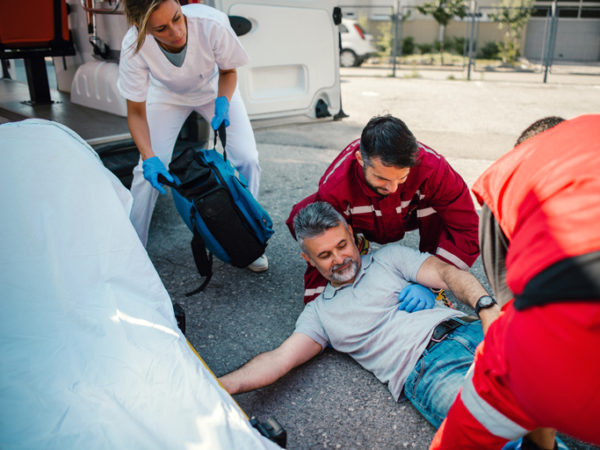 EMTs help a man who lying on the street after he was hit by a car