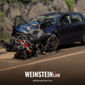After a serious motorcycle accident in Tyler, a motorcycle and car sit in the road, both heavily damaged.